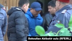 Икрамжана Илмиянова (в центре) выводят из здания Первомайского районного суда. 20 октября 2018 года.