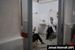 Infermieret e repartit të emergjencave duke pushuar në një dhomë, pas trajtimit të një numri të madh lëndimesh në spitalin Shifa.