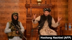 Imam u džamiji Abdul Rahman u Kabulu govori pored naoružanog talibana, 20. avgust 2021. 