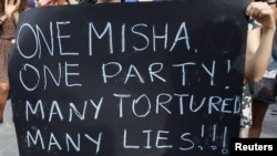 Тбилисидеги митингде студенттер президент Михаил Саакашвили жана кыйноо фактылары жөнүндө плакат кармап турушат, 26-сентябрь, 2012