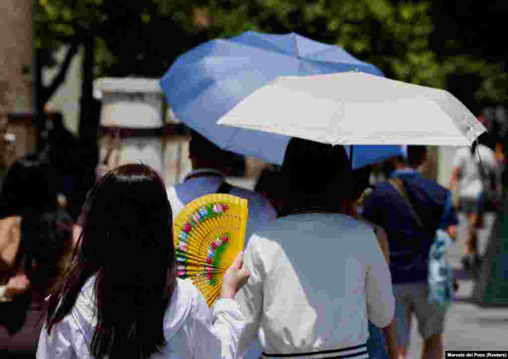 Жена се лади со лепеза на жештините во Севиља, 29 јуни.