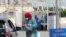 A health worker wearing a protective face mask takes someone's medical history at the drive-through screening and testing facility for coronavirus in Karachi on April 7. 