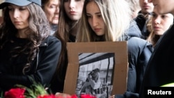 Studenții cu fotografii ale victimelor în timp ce semnează cartea de condoleanțe pentru victimele incendiului din Kocani. Skopje, 17 martie 2025.