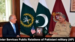FILE: U.S. peace envoy Zalmay Khalilzad (L) talks with Pakistani Army Chief General Qamar Javed Bajwa in Rawalpindi, December 2018.