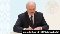 Alyaksandr Lukashenka signs the amendments into law in Minsk on May 24.