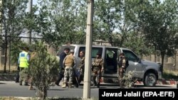 Afghan security officials inspect a vehicle used by the militants during attack on the Interior Ministry building in Kabul on May 30.