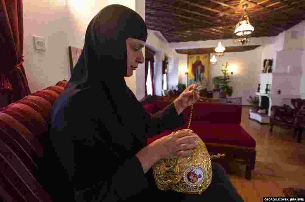 Черниця вшиває в митру дорогоцінні камені і маленькі ікони &nbsp;