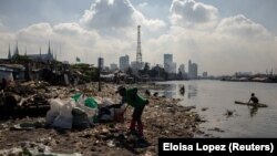 Angelita Imperio, "a folyó egyik harcosa" gyűjti zsákba a szemetet Manilában a Pasig folyó partján.