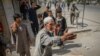 A man who was injured in a car bomb blast talks to people at the scene in Kabul on August 7.