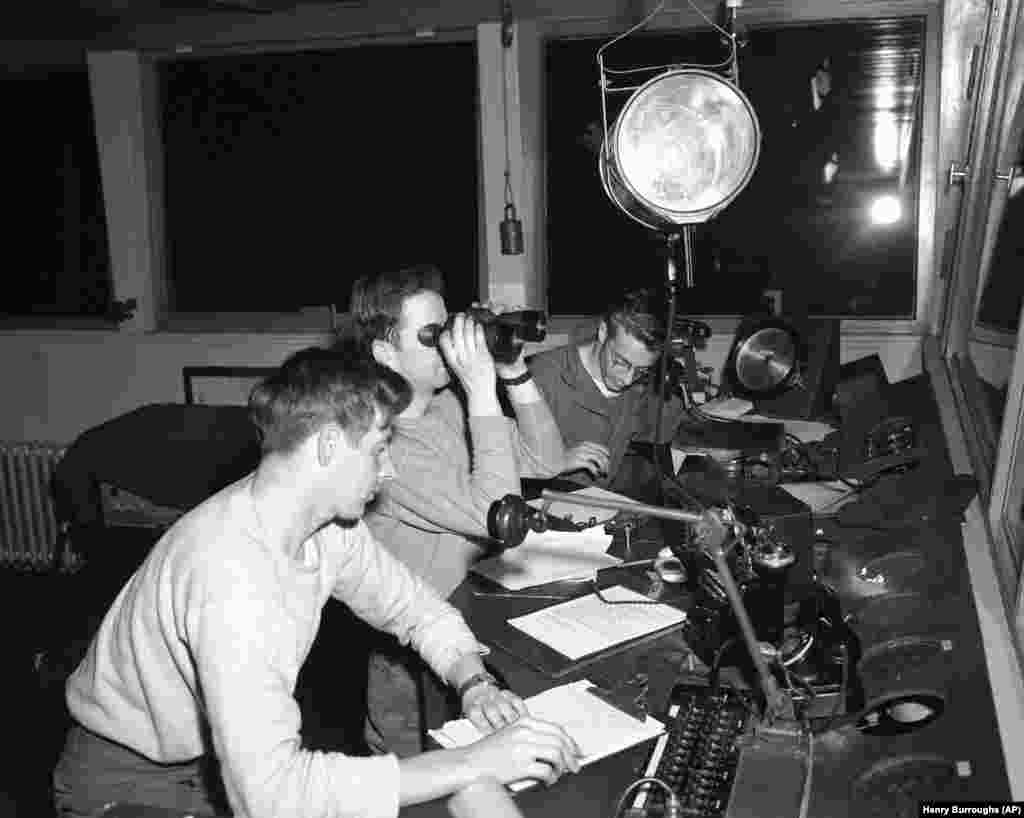 Trei soldați americani coordonează intensul trafic aerian de la Tempelhof la 1 iulie 1948.