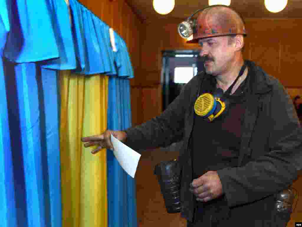 Шахтар заходить до кабінки для голосування в Донецьку