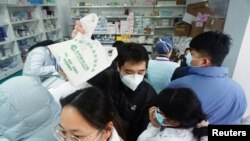 Covid-gyorstesztért sorban álló emberek egy patikában Hangcsouban