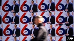 A passerby walks past election posters of the Serbian Progressive Party's (SNS) top candidate for the presidential election, Serbian Prime Minister Aleksandar Vucic, in Belgrade.