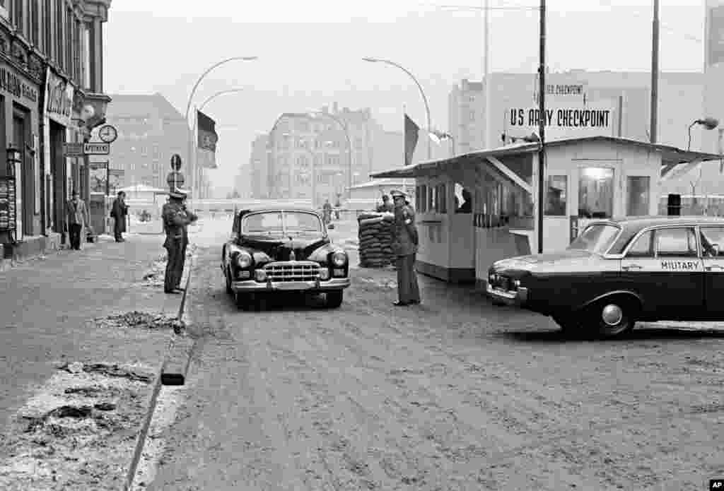 O mașină trecând de la est la vest de Berlin la Checkpoint Charlie în octombrie 1964. Punctul de trecere era singurul prin care străinii aveau voie să treacă.&nbsp;