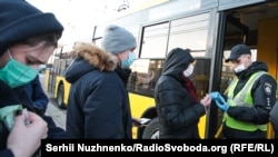 Працівник поліції перевіряє спеціальний квиток для проїзду у транспорті столиці