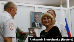 Ресей азаматтығын алған адамға құжат тапсыру рәсімі. Көрнекі сурет.