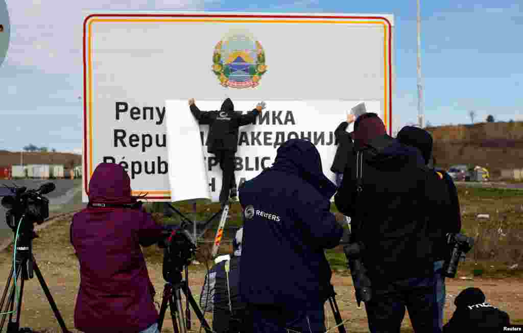 Punëtorët duke vendosur tabelën me emrin e ri.&nbsp;REUTERS/Ognen Teofilovski