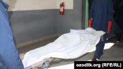 Сотрудники узбекской колонии выносят тело скончавшегося заключенного.  