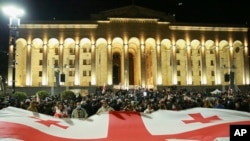 Фото из архива: демонстранты развернули флаг Грузии у здания парламента, требуя освобождения политзаключенных и проведения новых выборов, Тбилиси, 31.03. 2025