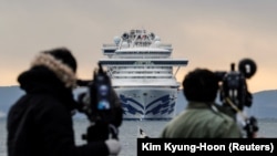 Јапонија- телевизиски екипи го снимаат патничкиот брод кој се наоѓа вкотвен во пристаништето Јокохама поради коронавирусот