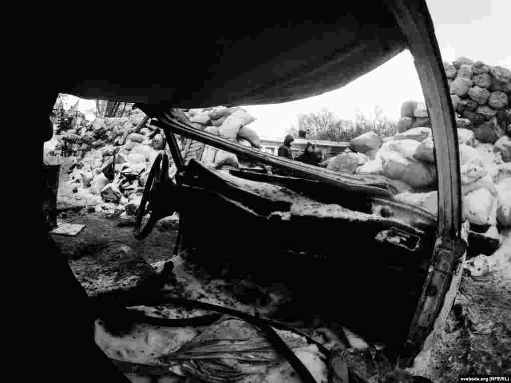 Mbeturinat e një automjeti të djegur nga një shpërthim dhune në rrugë.