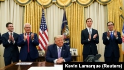 Președintele american Donald Trump este aplaudat de membri ai administrație după ce s-a anunțat că Israelul și Emiratele Arabe Unite au semnat acordul de normalizare a relațiilor, Washington, 13 august 2020.