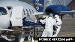 Orvosok egy Lyonból érkező koronavírusos beteget szállítanak kórházba Strasbourg repteréről 2020. november 6-án