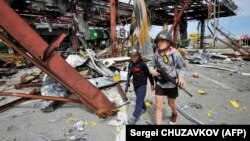 Українські діти, які граються у бійців територіальної оборони, «патрулюють» у селі Стоянка Київської області 19 травня 2022 року