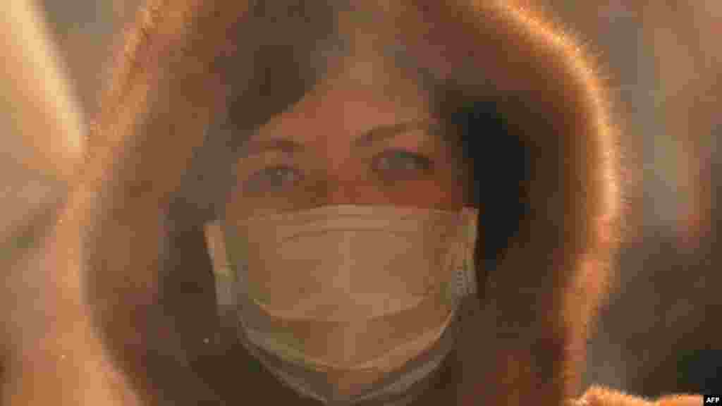 Жінка у масці проходить крізь пару, що піднімається від вареної кукурудзи в Москві