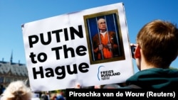 Протестующие у здания Международного суда ООН с требованием арестовать руководителя России Владимира Путина. Гаага, Нидерланды, 7 мая 2024 года