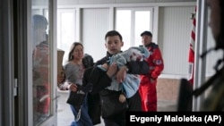 Аткылоодон чарчап калган 1,8 айлык наристени ооруканага жеткиришүүдө. Мариуполь. 4-март, 2022-жыл
