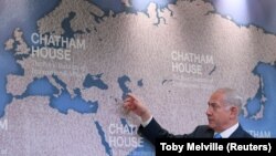 نخست‌وزیر اسرائیل روی نقشه‌ای در چتم‌هاوس در مورد نفوذ ایران در منطقه توضیح می‌دهد.