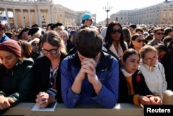 Credincioșii se roagă înainte de începerea slujbei de înmormântare a Papei Francis.