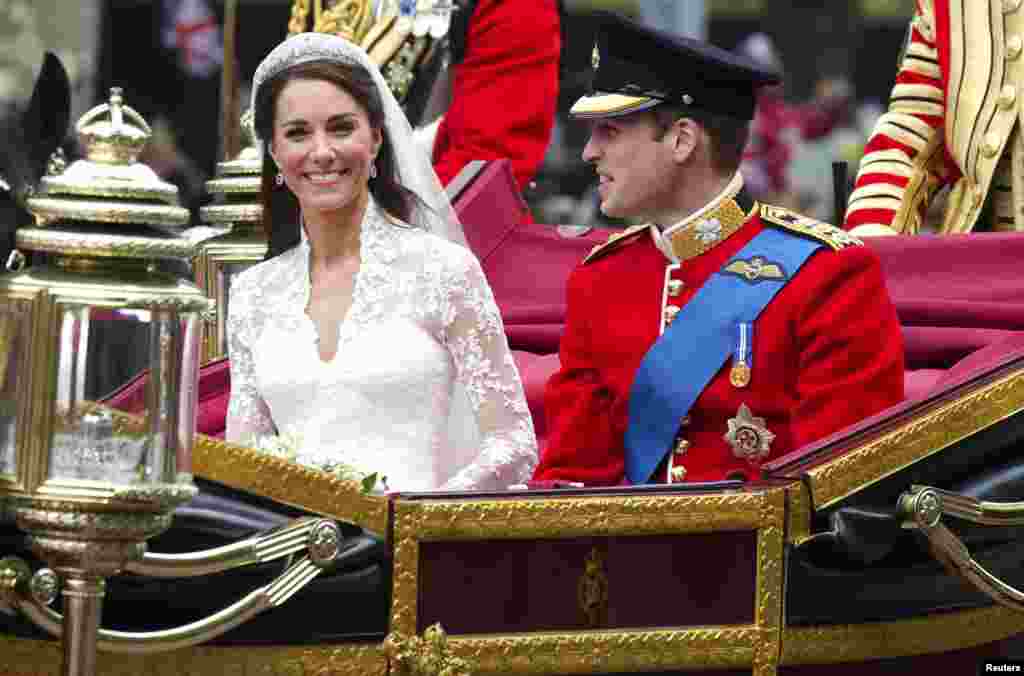 Британскиот принц Вилијам и неговата сопруга, Катерина, војвотката од Кембриџ, патуваат кон Бекингемската палата по нивната свадбена церемонија во Вестминстер во Лондон, на 29 април. 