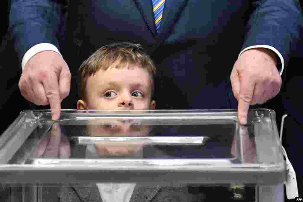 Президент України і кандидат на президентських виборах Петро Порошенко зі своїм онуком на виборчій дільниці у Києві