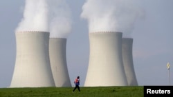 Ілюстраційне фото. Людина проходить повз градирні Темелінської АЕС у Чехії. Квітень 2014 року