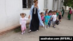 Türkmenistandaky çagalar baglarynyň birinde terbiýeçi zenan we çagalar