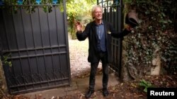 پتر هانتکه جلوی درِ باغش در فرانسه