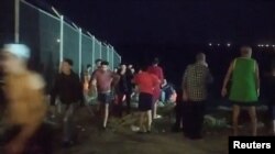 Migranti, koji su preplivali Maroko do Španije, napuštaju plažu u El Tarajalu, u Ceuti, u Španiji, 17. maja 2021.