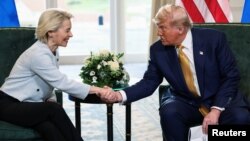 Председатель Европейской комиссии Урсула фон дер Ляйен и президент США Дональд Трамп пожимают руки после подписания торгового соглашения между ЕС и США. Шотландия, 27 июля 2025 года