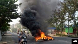 Gumiabroncsok égetésével tüntetnek a katonai puccs ellen a mianmari Rangun városában, 2021. március 24-én