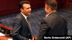 Macedonian Prime Minister Zoran Zeav (left) talks with leftist SDSM party lawmaker Tomislav Tuntev during a session for the ratification of the deal with Greece, in the parliament in Skopje on June 20.