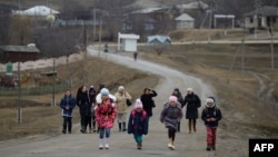 Copii și profesori, întorcându-se acasă de la școală în satul Bumbăta