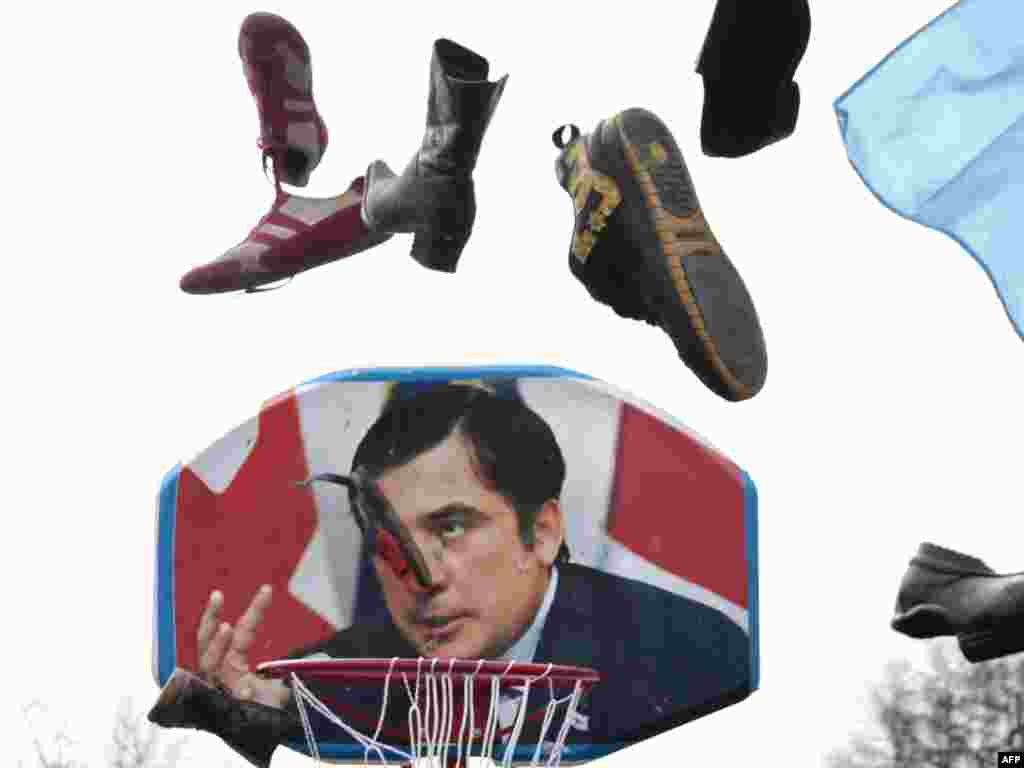 Членови на руска провладина организација фрлаат чевли врз сликата на грузискиот претседател Саакашвили