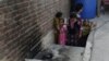 Pakistani residents stand at the site where a young woman was burnt alive by her mother in Lahore on June 8.