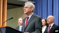 Merrick Garland, ministrul Justiției din SUA, anunțând acuzații la adresa soldaților ruși la o conferință de presă, în compania ministrului de Interne, Alejandro Mayorkas (în dreapta). 6 decembrie 2023, Washington DC (AP Photo/Mark Schiefelbein)