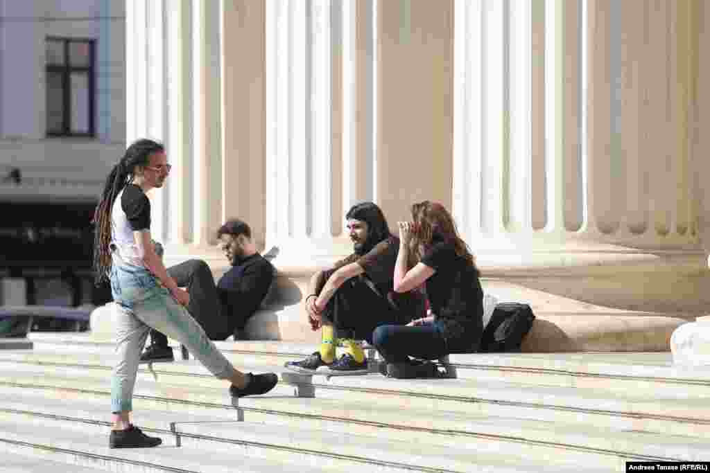 &nbsp;Tineri care stau de vorbă pe treptele Ateneului Român din București.