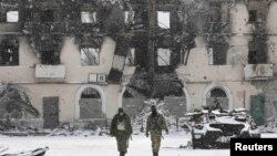 Бойовики угруповання ​​«ДНР» біля зруйнованої внаслідок бойових дій будівлі. Вуглегірськ, 16 лютого 2015 року