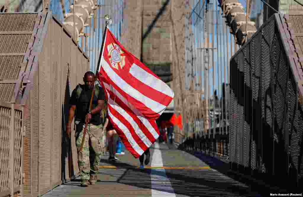 Muškarac nosi zastavu Vatrogasnog udruženja Njujorka na godišnjicu terorističkog napada