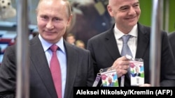Президент Росії Володимир Путін (л) та президент ФІФА Джанні Інфантіно позують із ідентифікаційними картками вболівальника чемпіонату світу з футболу, Сочі, 3 травня 2018 року